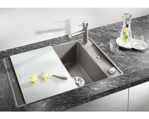 Küchenspüle mit Armatur, Schneidebrett, Messer und Sternfrucht auf einer Küchentheke.