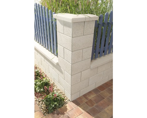 Gartenmauer aus Betonsteinen mit Zaunpfosten und Pflanzen