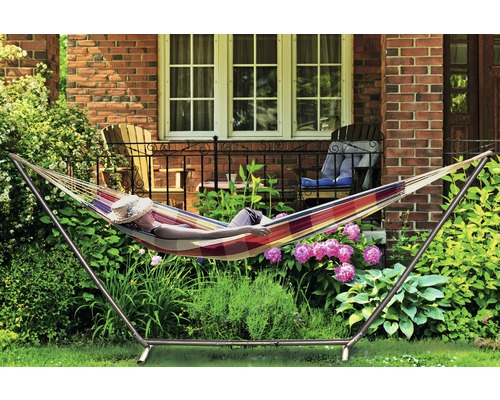 Person entspannt in einer Hängematte mit Gestell im Garten.