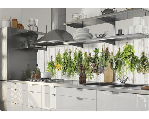 Küchenszene mit weißen Schränken, Edelstahlspüle und Kräutermotiv auf der Rückwand