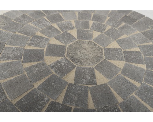 Kreisförmiges Pflastermuster aus Betonsteinen mit sandgefüllten Fugen.