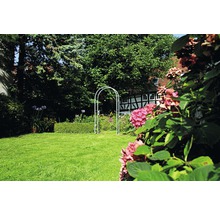 Garten mit Rasenfläche und Rosenbogen