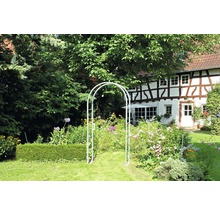 Gartenansicht mit Gartenbogen, Blumen und Fachwerkhaus im Hintergrund
