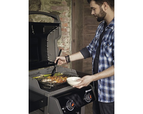 Mann bereitet Speisen auf einem Weber Spirit Gasgrill zu.