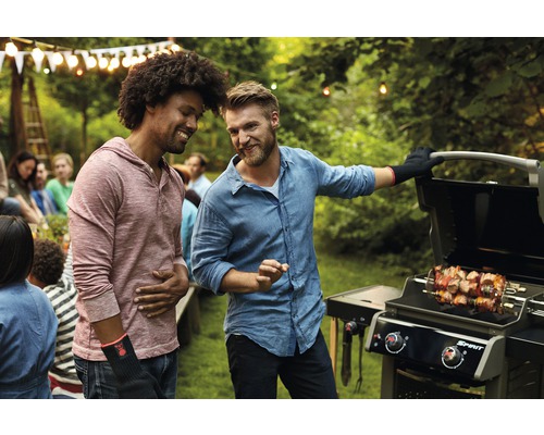 Zwei Männer am Grill mit Spießen bei einer Gartenparty