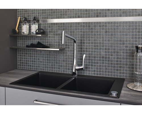 Spüle mit Wasserhahn vor Mosaikfliesenwand