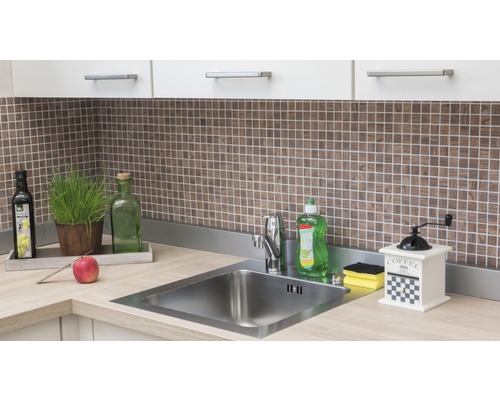 Küchenspüle mit Armatur, Spülmittel, Kaffeemühle und Dekoration auf der Arbeitsplatte vor Mosaikfliesen