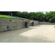 Terrasse mit Steinmauer und beigen Steinplatten