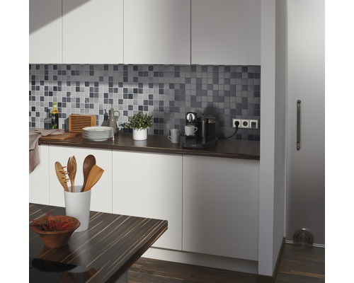 Küchenszene mit Mosaikfliesen, Arbeitsplatte, Küchenutensilien und Esstisch