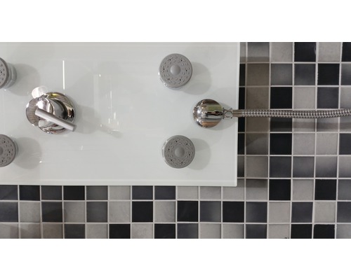Duschelement mit mehreren Duschköpfen und Armatur vor einer Mosaikwand