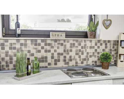 Küchenszene mit Mosaikfliesen, Kochfeld und dekorativen Elementen.