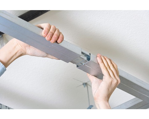 Hände verbinden Metallprofile für Trockenbau