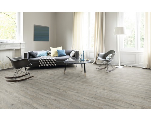 Heller Wohnraum mit Laminatboden, Sofa und zwei Schaukelstühlen.