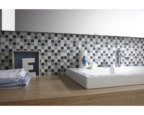Badezimmer mit Mosaikfliesen, Waschbecken und Armatur auf einem Waschtisch