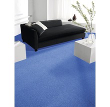 Wohnzimmer mit blauem Teppichboden, schwarzem Sofa und weißen Beistelltischen.