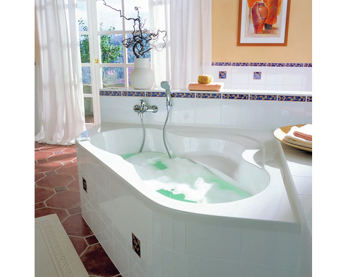 Badezimmer mit Eckbadewanne, Armatur, Deko und Fenster