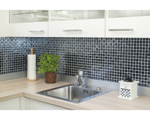 Küchenspüle mit Armatur, Fliesen, Kräutertopf, Papierhandtuchhalter und Kaffeemühle auf einer Küchentheke