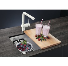 Küchenszene mit Spüle, Armatur, Schneidebrett und Smoothies