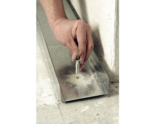 Hand befestigt eine Schraube mit Dübel in ein Metallprofil