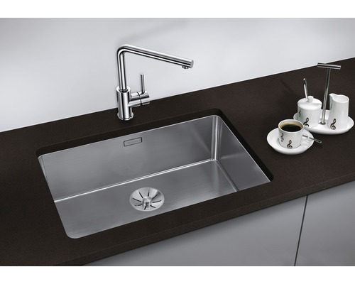 Spültisch mit Wasserhahn und Abtropffläche auf einer dunklen Arbeitsplatte