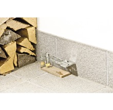 Lebendfalle für Mäuse aus Drahtgitter mit Köder neben einem Holzstapel