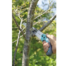 Gartenarbeit mit einer Astsäge beim Beschneiden eines Baumastes