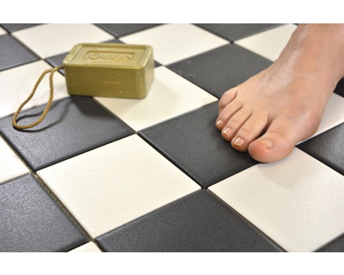 Szene mit Schachbrettfliesen, einem Stück Seife und einem Fuß