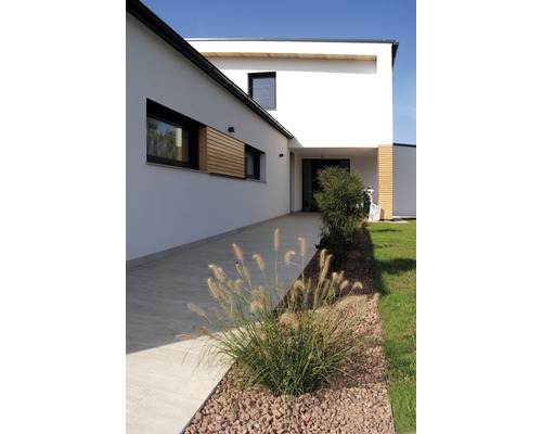 Außenansicht eines modernen Hauses mit Gartenweg und Bepflanzung
