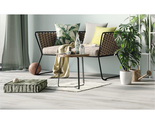Wohnzimmer-Szene mit Sofa, Tisch, Kissen und Pflanzen für eine gemütliche Atmosphäre.