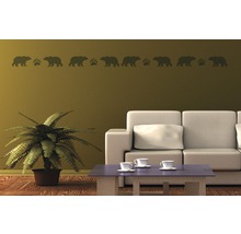 Wohnzimmer mit Wandtattoo, das Bären und Tatzen zeigt, einem Sofa, einem Tisch und einer Pflanze
