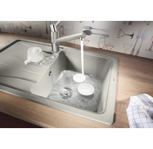 Spüle mit Wasserhahn und Geschirr auf einer Arbeitsplatte