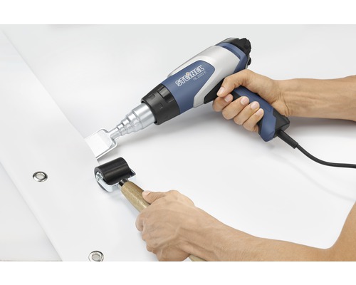 Heißluftpistole und Andrückrolle im Einsatz auf Plane