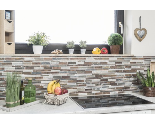 Küchenszene mit Mosaikfliesenwand, Kräutern, Obstschale und Kochfeld