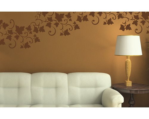 Dekoratives Wohnzimmer mit Wandtattoo über Sofa und Lampe auf einem Tisch