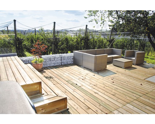 Gartenszene mit Holzterrasse, Gabionenwand und Rattansitzgruppe
