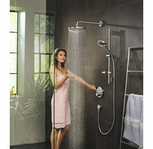 Frau unter einer Duschgarnitur mit Kopfbrause und Handbrause in einem modernen Badezimmer