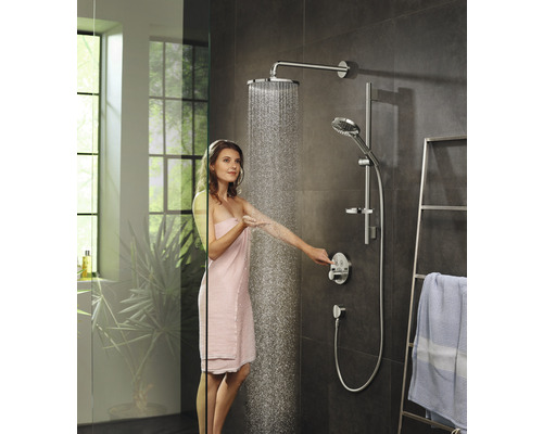 Frau unter einer Duschgarnitur mit Kopfbrause und Handbrause in einem modernen Badezimmer