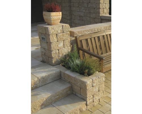 Außenbereich mit Steintreppe, Steinmauer, Holzsitzbank und bepflanzten Steinelementen