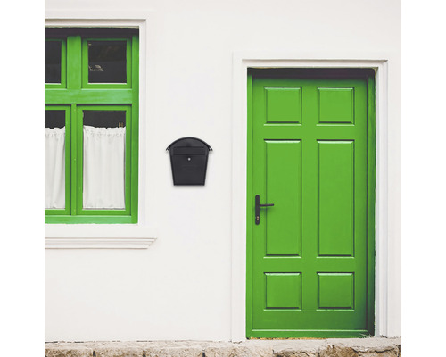 Eine Hausfassade mit Fenster, Tür und einem schwarzen Briefkasten.