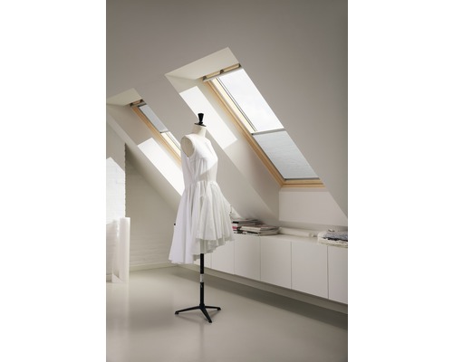 Dachgeschosszimmer mit zwei Dachfenstern, weißem Einbauschrank und Schneiderpuppe mit weißem Kleid