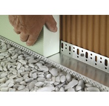 Detailaufnahme der Installation einer Perimeterdämmung mit Sockelprofil, Dämmplatten und Kies