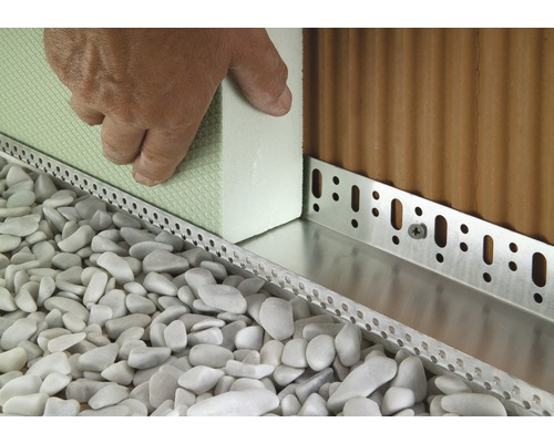 Detailaufnahme der Installation einer Perimeterdämmung mit Sockelprofil, Dämmplatten und Kies