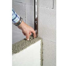 Person befestigt Dämmplatte mit Montageschiene an einer Wand