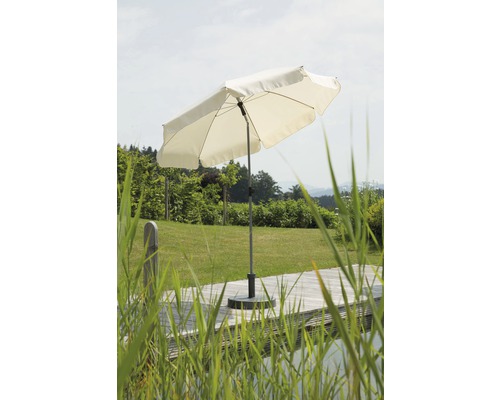 Offener Sonnenschirm auf einer Terrasse mit Garten im Hintergrund
