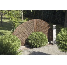 Gartenlandschaft mit Flechtzaun, Büschen und Gehwegplatten