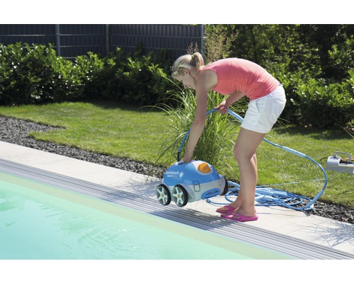 Frau bedient einen Poolreinigungsroboter am Pool