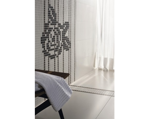 Badezimmer mit Mosaikwand und Handtuch auf einer Bank