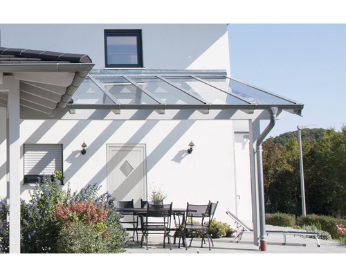 Terrasse mit Glasüberdachung und Gartenmöbeln am Haus