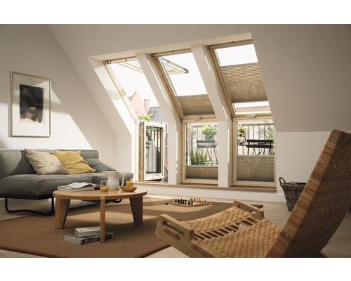 Wohnzimmer mit Dachfenstern, Sofa, Couchtisch und Korbstuhl