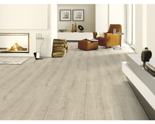Heller Wohnraum mit Kamin, Sessel und Laminatboden